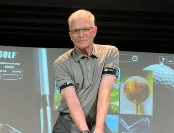 Gaylord Rhodes holding a club in his indoor teaching studio