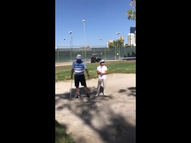 Coach and student in a greenside bunker